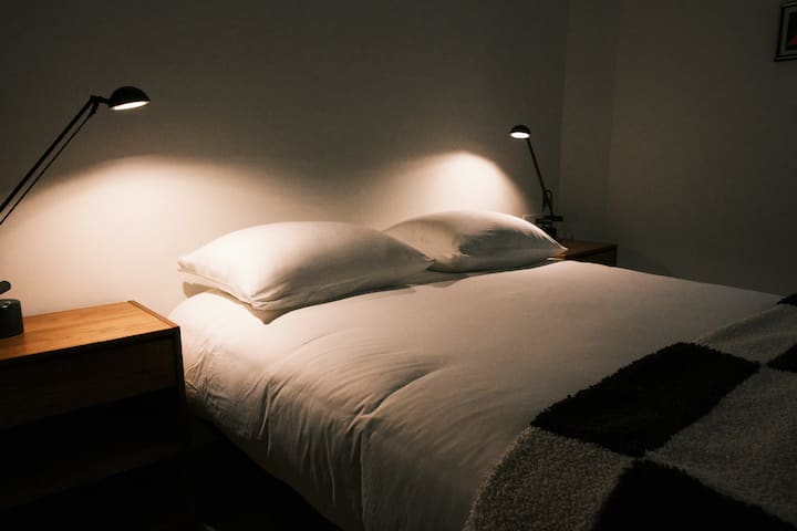 One of two cozy downstairs bedrooms, with queen-sized bed, 400 thread count sheets, premium pillows, and vintage teak night stands. 