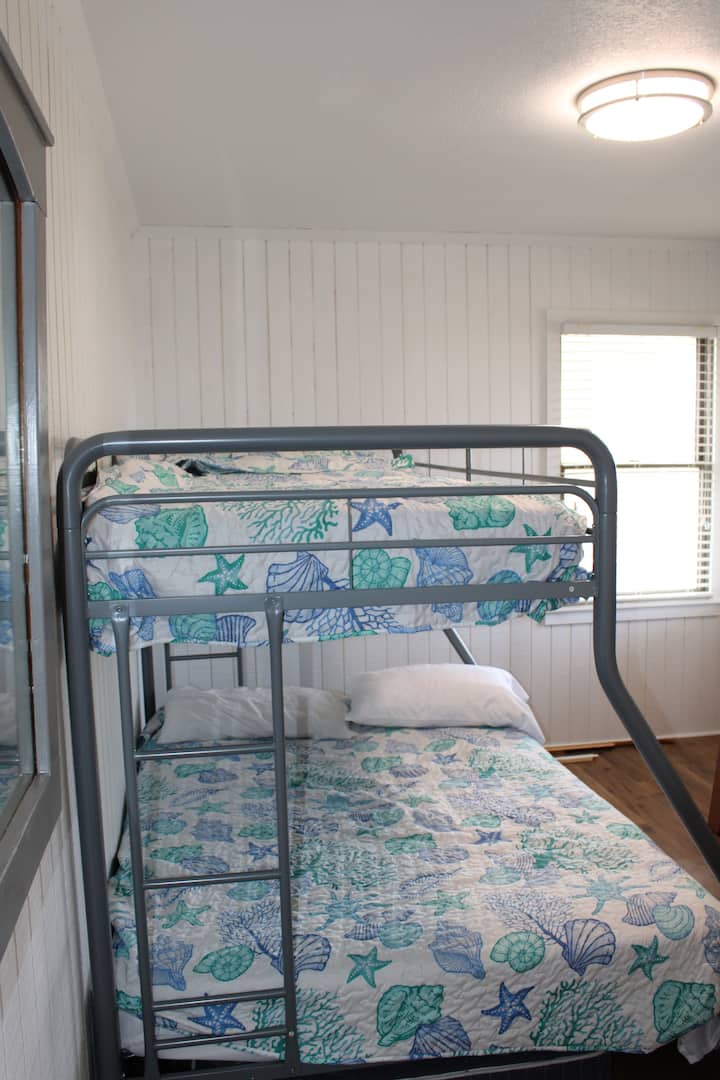 The bunk bed room offers a triangle bunk option so a twin bed on top and a full bed on the bottom. This room is located on middle level along with the twin bed room, full bath,  and a master bedroom with attached bath. Each bedroom has a Smart TV.
