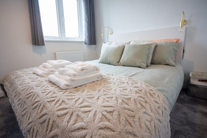 طقم سرير مزدوج مع بياضات ووسائد. المناشف متاحة. تطل النوافذ على حقل مفتوح. الإضاءة متاحة. غير مصورة ولكن الطاولة الجانبية للسرير متاحة أيضًا. 