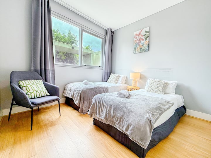 חדר שינה שני עם 2 מיטות יחיד וארון.