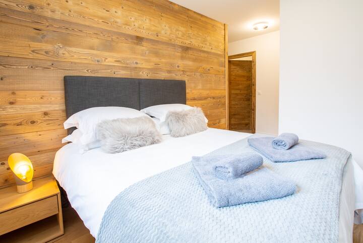 Spálňa s manželskou posteľou a vlastnou kúpeľňou so sprchovacím kútom.