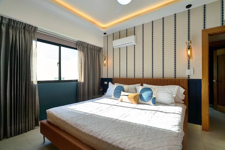 Úžasná druhá spálňa má luxusnú manželskú posteľ King, luxusný matrac, klimatizáciu, stropný ventilátor, zatemňovacie závesy, okolité svetlá, priestrannú skriňu, inteligentnú televíziu, písací stôl, krásny výhľad na mesto a luxusnú vlastnú kúpeľňu s dažďovou sprchou.