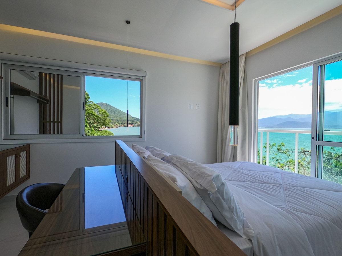 Slaapkamer 1 - Met een tweepersoonsbed, thuiskantoor en balkon met weids uitzicht op zee