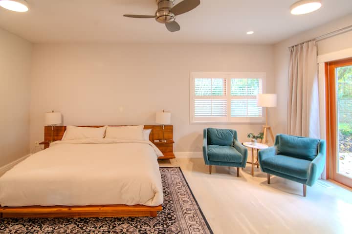 Second bedroom with king bed, seating area and French doors overlooking a small private patio.  