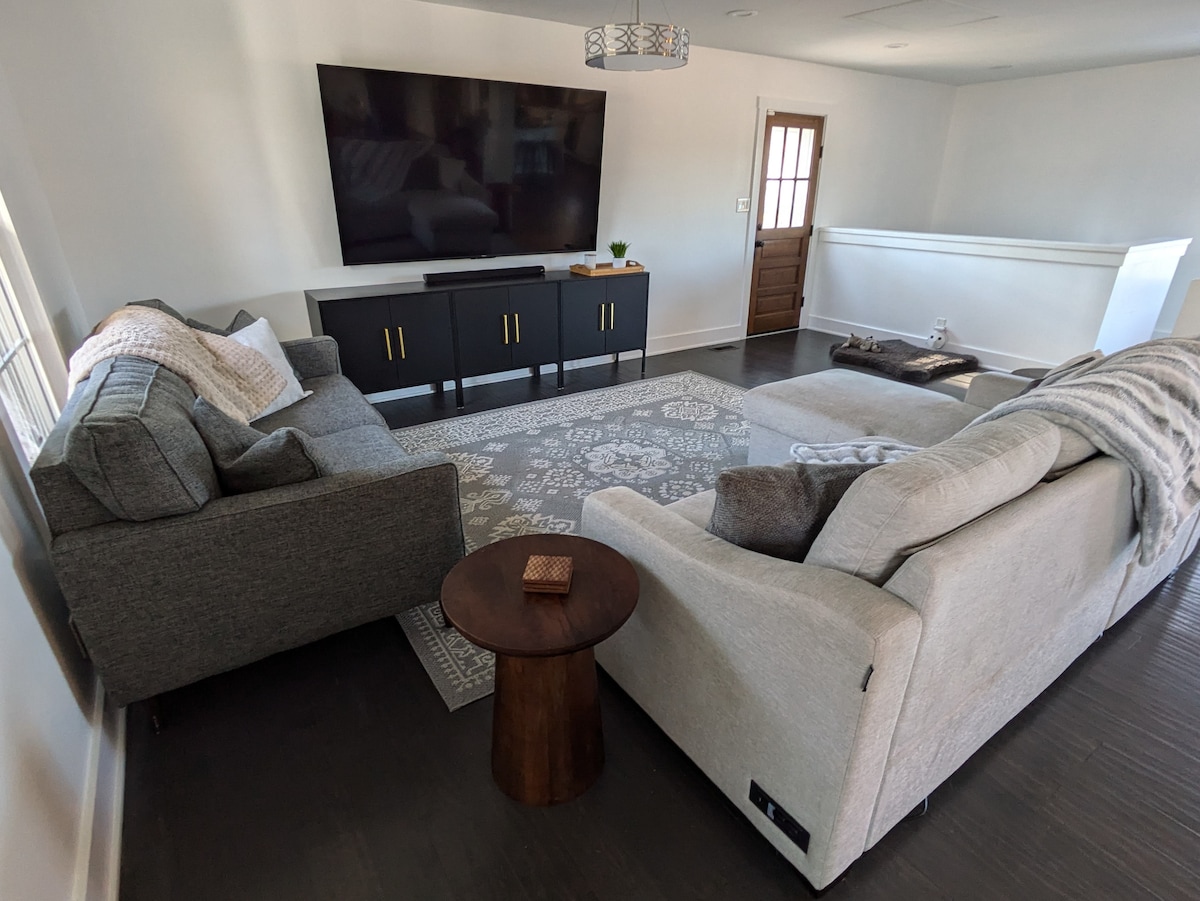 جلوس مريح في غرفة المعيشة، تلفزيون 85بوصة مع صوت مزدهر. 