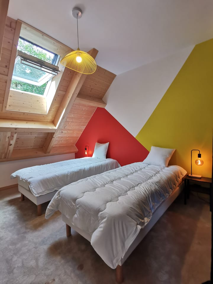 חדר צהוב ואדום מצויד במיטות זוגיות ושמיכות פוך עם צמרות גדולות שיכולות להיסגר הודות לווילון האפלה גדול. ארונות ומתקני אחסון שונים זמינים.