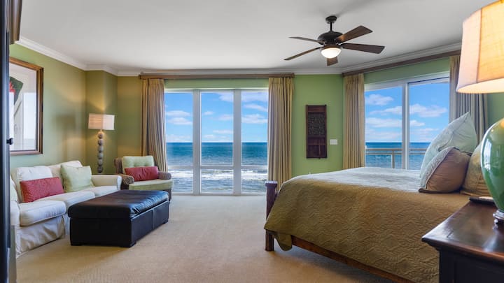 Dormitorio 1 con vista a la ventana del piso al techo del mar y la playa.