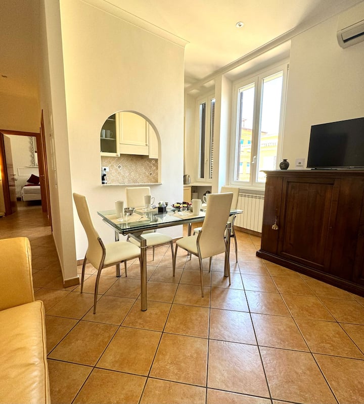 Área de almuerzo, estante con TV inteligente, sofá cama, pasillo donde puedes ver el dormitorio 1