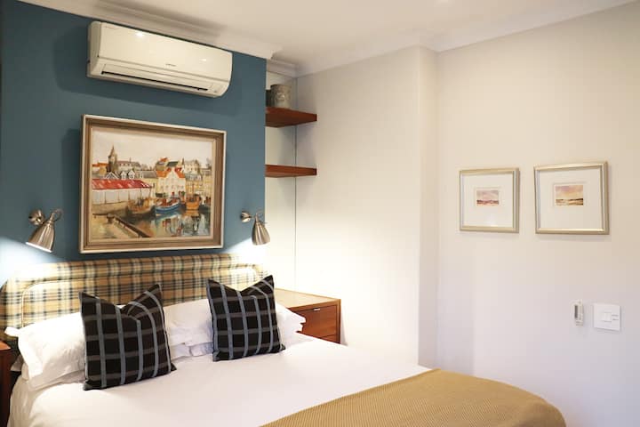 ห้องนอน 1 มีเครื่องปรับอากาศ และมีปลั๊กไฟและโคมไฟอ่านหนังสืออยู่ข้างเตียงแต่ละด้าน