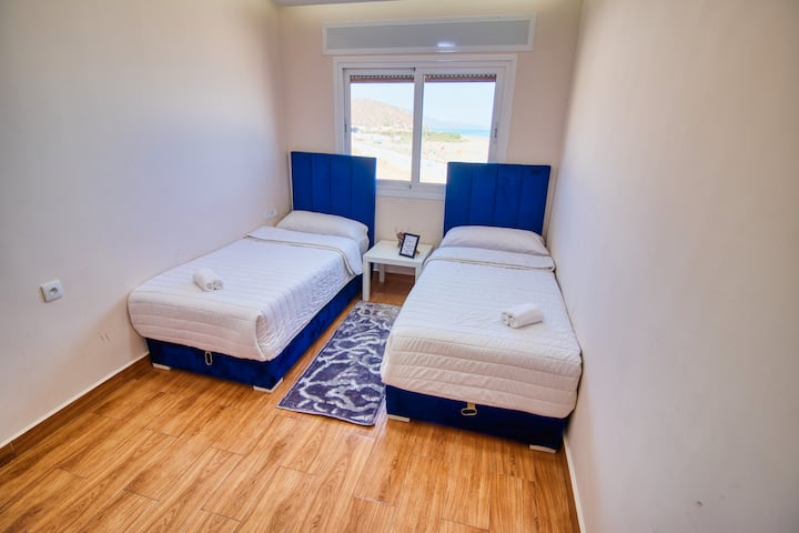 Una habitación con dos cómodas camas para dos personas y impresionantes vistas al mar