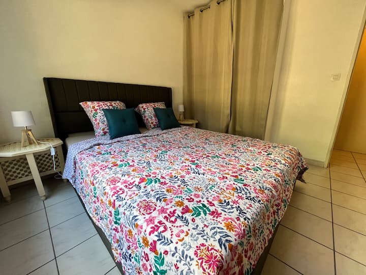 إطلالة على غرفة النوم بسرير مزدوج ومنضدتين ليليتين