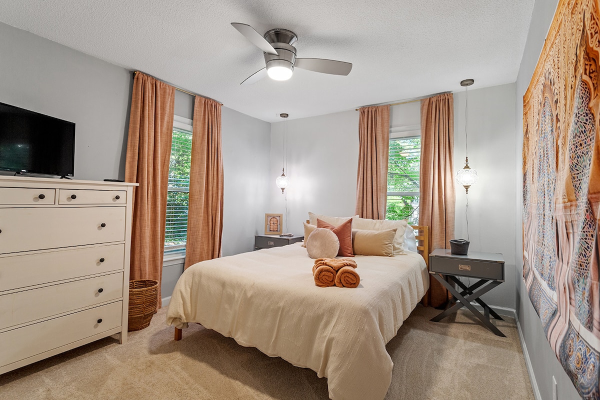 Спокојна спална соба со мека постелнина и многу природна светлина.