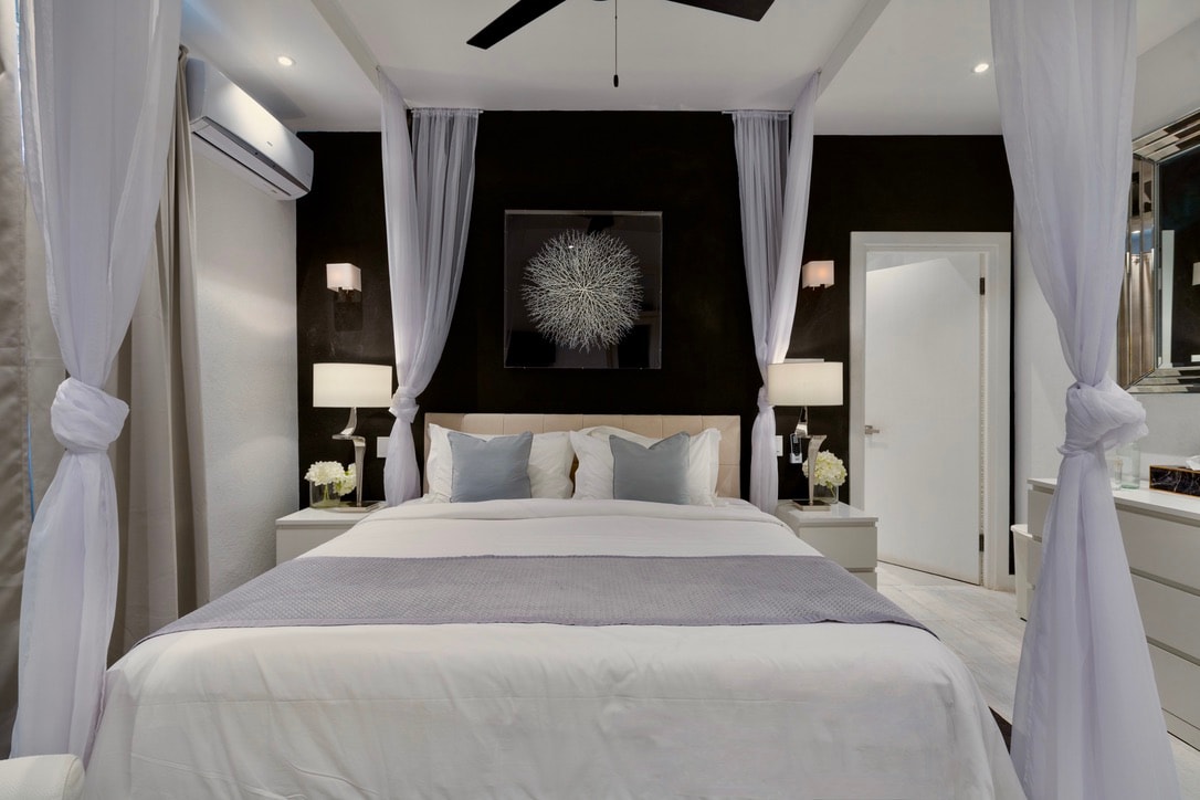 Schlafzimmer 4 mit Deckenventilator, Soundsystem, Smart-TV, Klimaanlage, eigenem Bad und einem weichen Kingsize-Bett.