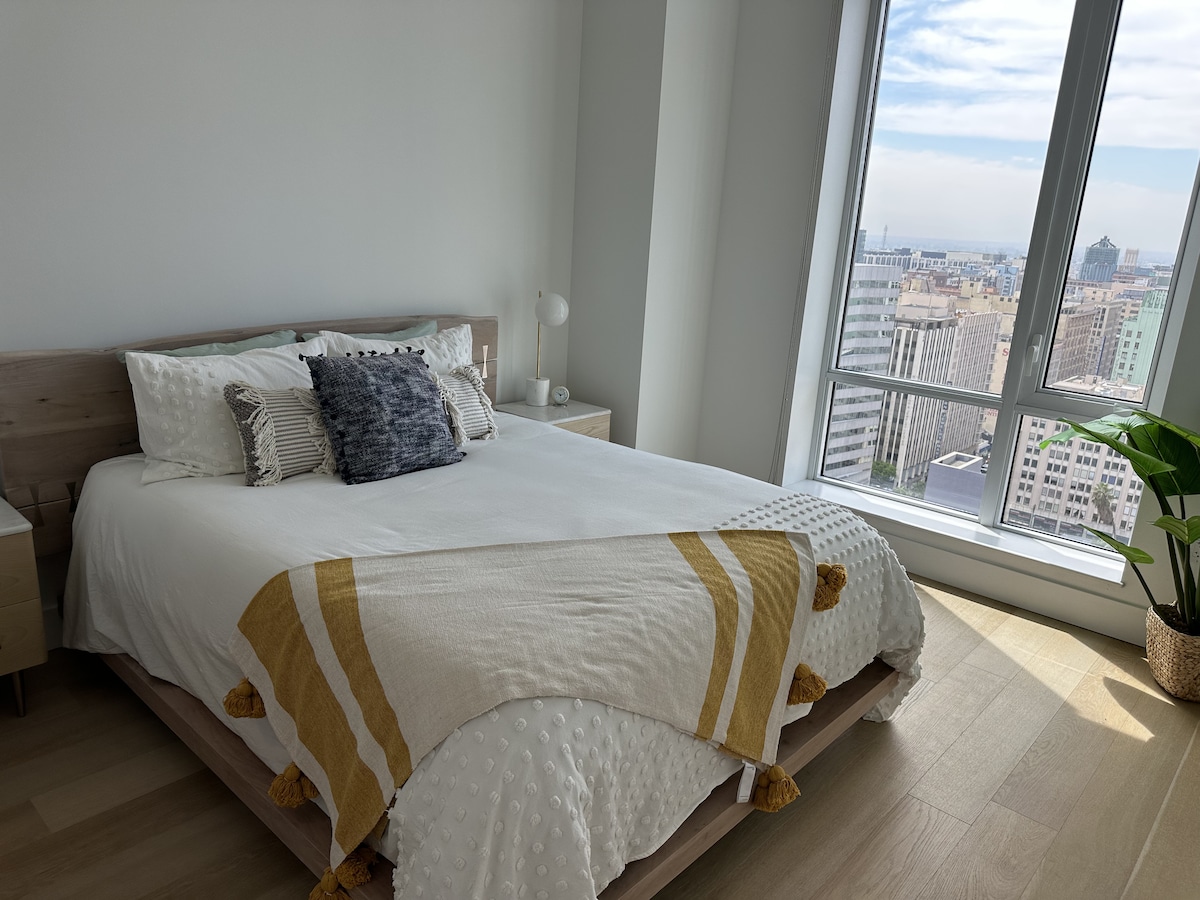 El descanso de lujo se encuentra con el amanecer tranquilo, vistas a la ciudad desde tu cama.