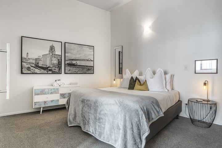 El espacioso segundo dormitorio con cama tamaño king cuenta con un juego de cajones y un armario para un cómodo almacenamiento. Las puertas corredizas se abren hacia la sala de estar para una sensación espaciosa y conectada, mejorando el diseño de planta abierta al tiempo que ofrece privacidad cuando es necesario.