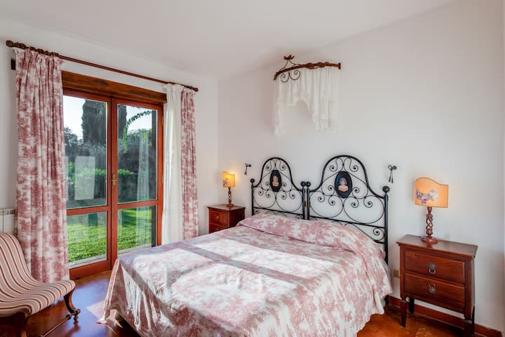 Svijetla spavaća soba s bračnim krevetom na donjem katu s privatnom kupaonicom, prostorom za učenje i pristupom vrtu.