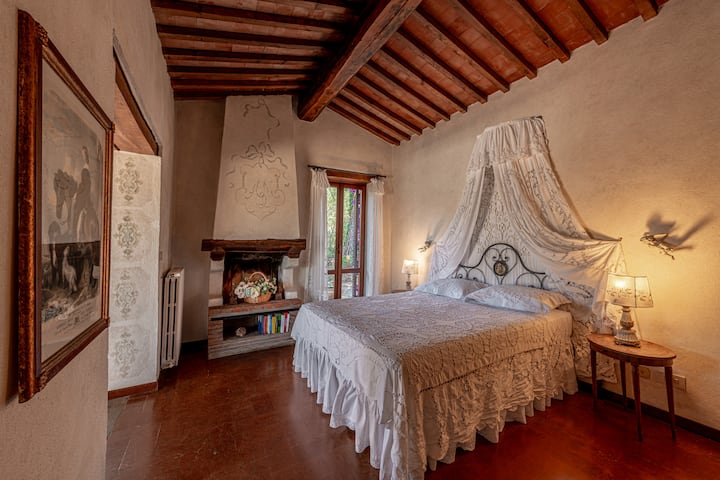 Prva spavaća soba na gornjem katu s bračnim krevetom s četiri postera, kaminom i pogledom na vanjski dio.