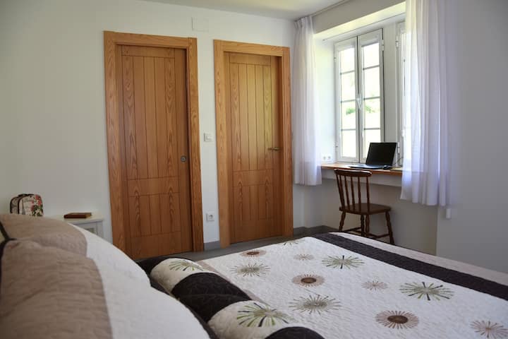 Spálňa s pracovným priestorom a televízorom