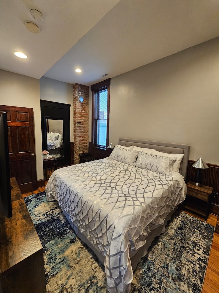 Private Bedroom with a comfortable king size bed,  full closet with hangers, drawers and shelves, big screen tv, full body mirror, two benches for sitting and setting your luggage, direct access to full bathroom and laundry area.