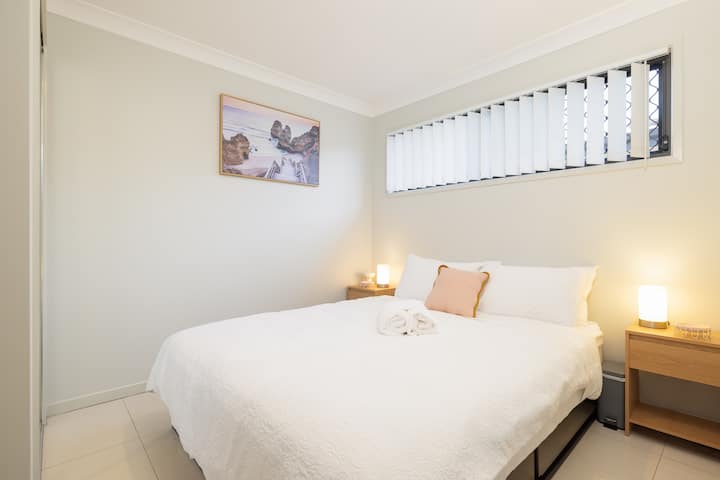 El dormitorio cuenta con una cama tamaño queen, diseñada para el confort y la relajación. Con fácil acceso a un armario privado, este espacio es perfecto para descansar y recargar energías. El mobiliario moderno de la habitación y el ambiente tranquilo garantizan una sensación acogedora y hogareña.