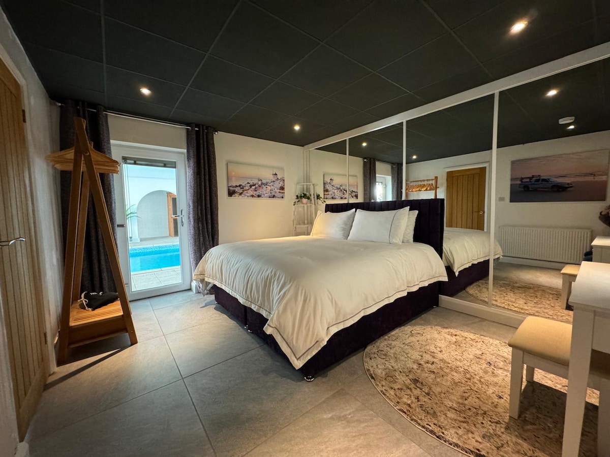 Cama Super King (se puede dividir en 2 individuales  si se solicita en el momento de la reservación). El dormitorio tiene acceso directo a la piscina, lo que proporciona luz natural. Este dormitorio no es apto para niños sin supervisión debido al acceso directo a la piscina.