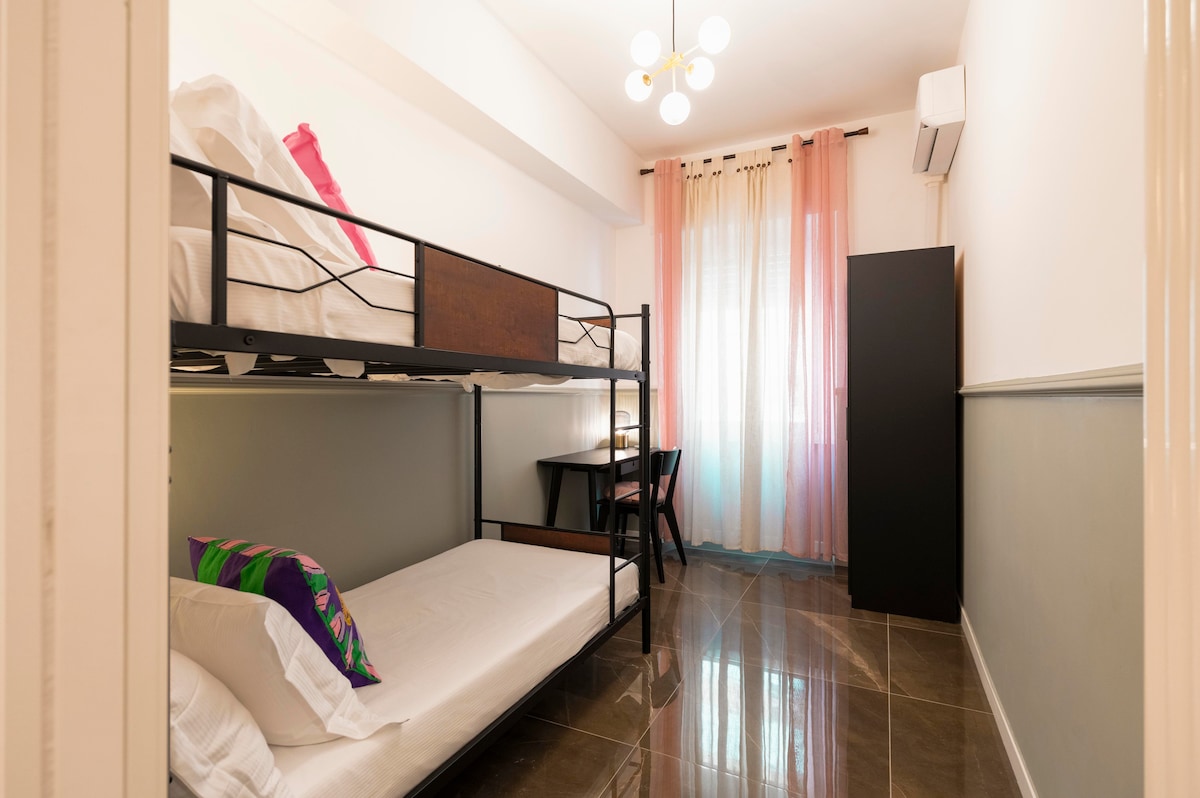 Chumba cha starehe kilicho na kitanda cha ghorofa chenye taa mbili za kusoma, kabati la milango miwili, kiyoyozi na kona ya ofisi