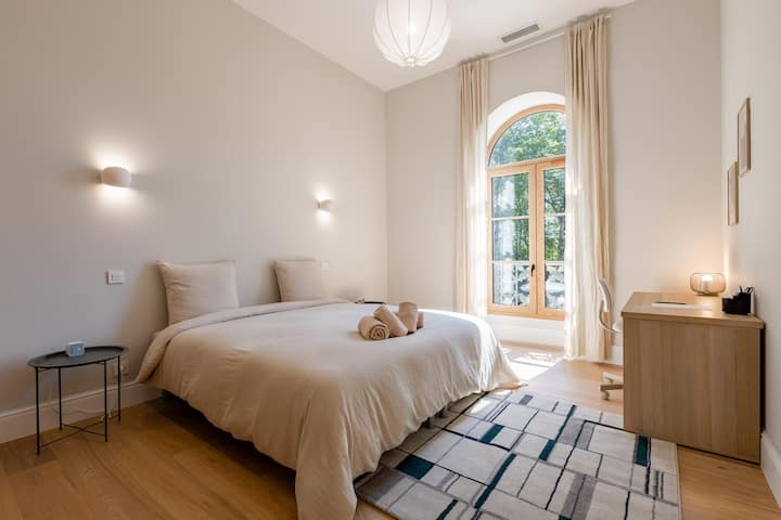 Svijetla soba s radnim stolom i velikim ormarom.