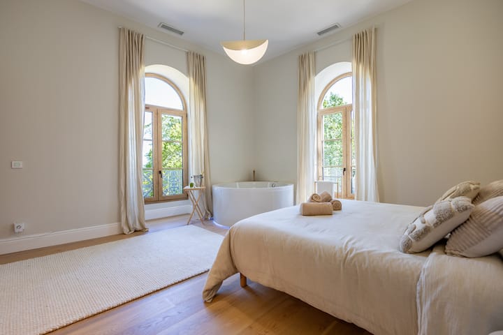 Spavaća soba u glavnom apartmanu sa spojenom kupaonicom i garderobom. Široki prozori pružaju prostor osvijetljen.