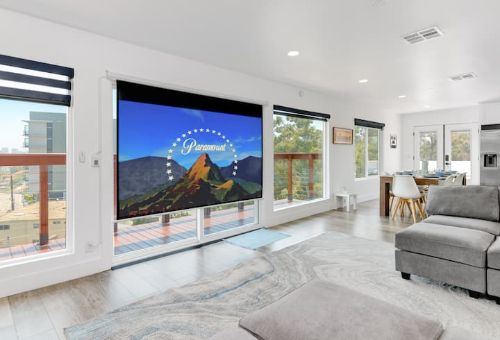 סלון שני, הממוקם למעלה, מציע מסך מקרן נפתח גדול המספק חוויה דמוית קולנוע בסלון למעלה.