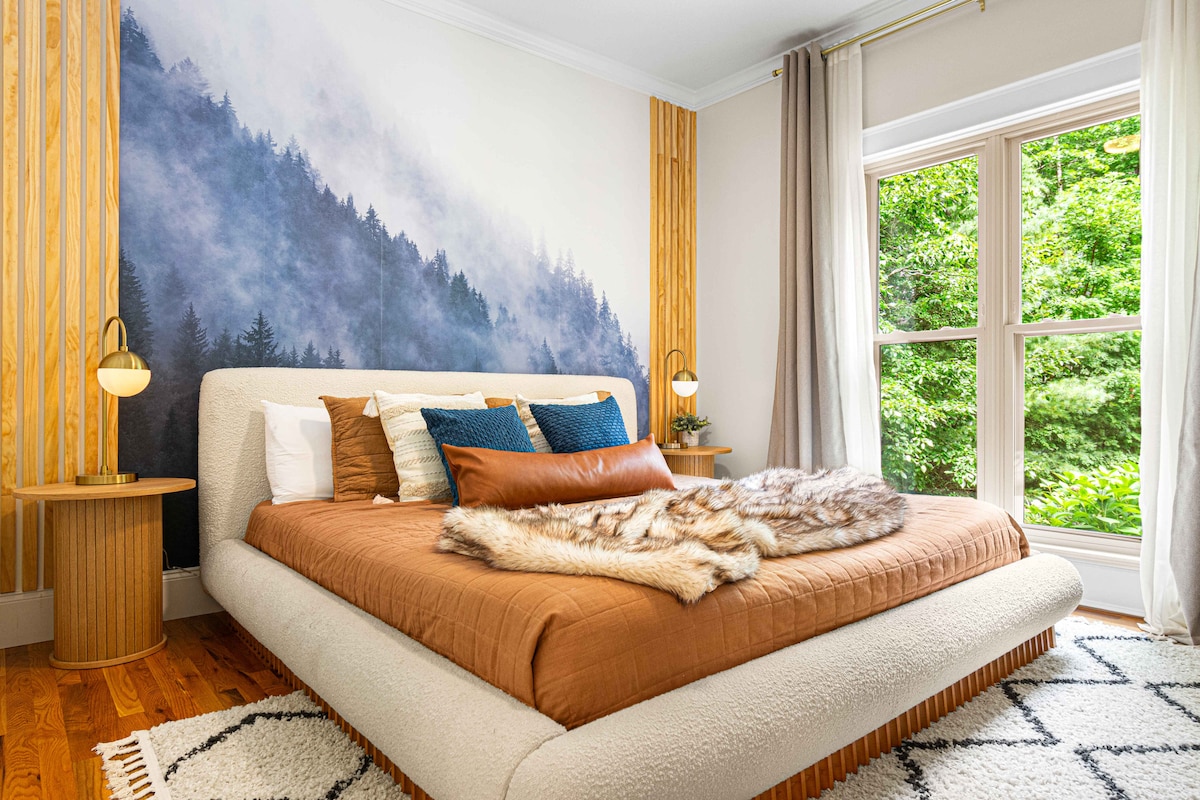 Çlodhu në dhomën e dytë të gjumit në katin kryesor, me një krevat dopio "King" dhe një mural të bukur të një pylli, të projektuar me elegancë dhe rehati në mendje.