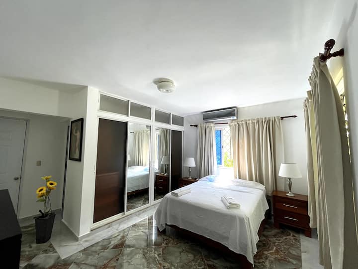 Štvrtá izba má dva nočné stolíky (každý s 2 zásuvkami), dve malé lampy, ventilátor na nohy, klimatizáciu, výhľad na prednú časť domu, priestrannú skriňu, inteligentnú televíziu a drevený bočný nábytok s 5 zásuvkami.