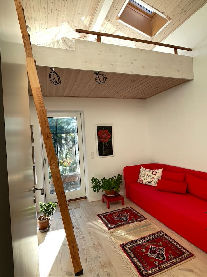 Quarto com sofá-cama: saída para um conservatório exuberante e aconchegante com vista para o pôr do sol. Banco e mesa pequena.
Escadas até um loft grande com 2 endereços de espuma. Principalmente para crianças e jovens. 
A escada está presa à parede, que pode ser movida para fora e para dentro quando não estiver em uso