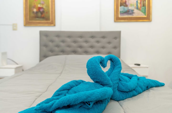 

"Recámara con vista panorámica impresionante✨. Decorada con cuadros artísticos, mesas de luz laterales y respaldo elegante. Un espacio para relajarte y disfrutar"