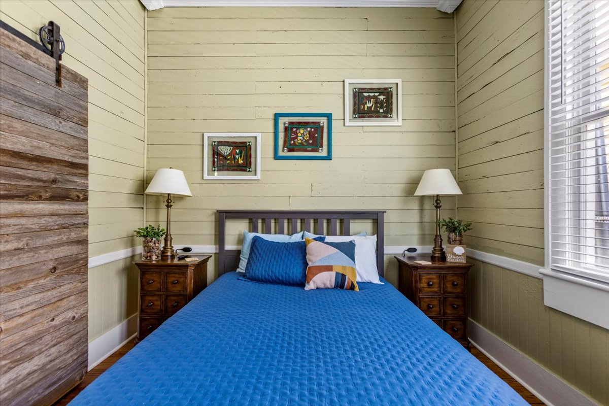 -舒适的客房，配备全尺寸床、配套的木制床头柜和丰富的蓝色床上用品
- 垂直木板墙和折中主义框架艺术为房间营造温馨而艺术的氛围
- 完美的度假胜地，可享受宁静的夜晚或宁静的午后小睡