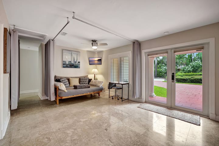 A versatile living area featuring a futon, easily transformed into an additional sleeping option. The space is enhanced by curtains, offering both privacy and comfort for guests.