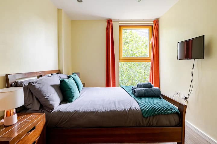 卧室景观，配有电视、床头柜和衣物储物柜。 为每位房客提供1条毛巾