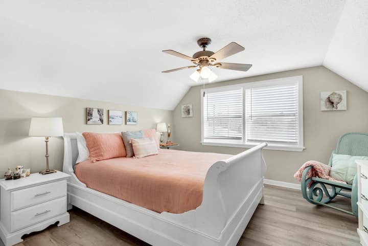 Chumba cha nne cha kulala kina kitanda aina ya queen, feni ya dari kwa ajili ya starehe na kiti kizuri cha kutikisa kwa ajili ya mapumziko. Ni sehemu yenye starehe na ya kukaribisha inayofaa kwa ajili ya kupumzika baada ya siku yenye shughuli nyingi.