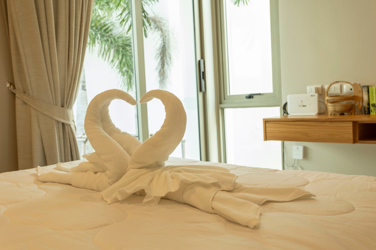 Отпуснете се в голямо двойно легло с плюшено спално бельо, прохладен климатик и щори за затъмняване на стаята. Плъзгащата се стъклена врата и близката баня добавят лекота, с уютно кътче за четене за допълнителен комфорт.