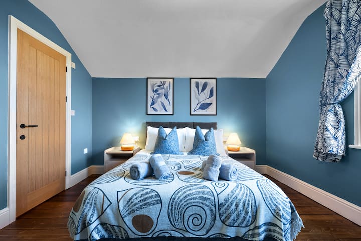 在Blue Puffin Stays Short Lets & Serviced Accommodation的双人床卧室中放松身心，配备优质床、高档床上用品和舒适的灯罩，是探索一天后享受宁静夜晚的理想之选
