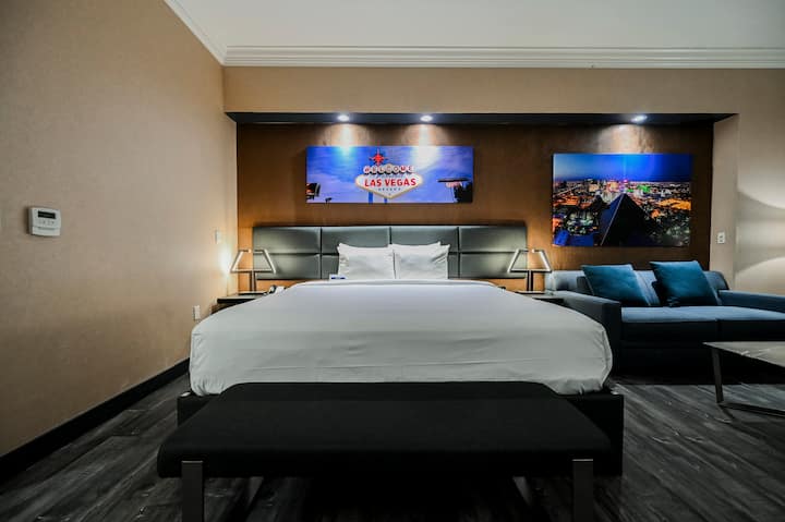 King Bed with Vegas Sign Art and Sofa