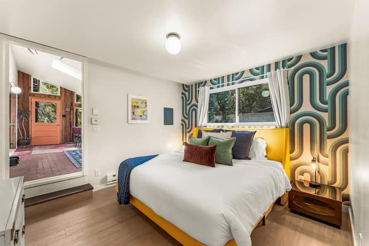 Svegliati riposato in questa vivace camera da letto, completa di biancheria da letto di lusso e una parete caratteristica.