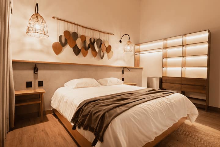 Starehe katika chumba hiki cha kifalme chenye bafu la kujitegemea, mapambo ya ukuta ya ufundi na mwangaza laini. Miguso yenye umakinifu kama vile nguo za safu na luva za rangi nyeusi huhakikisha usiku wenye utulivu wa Provenza. ️✨

