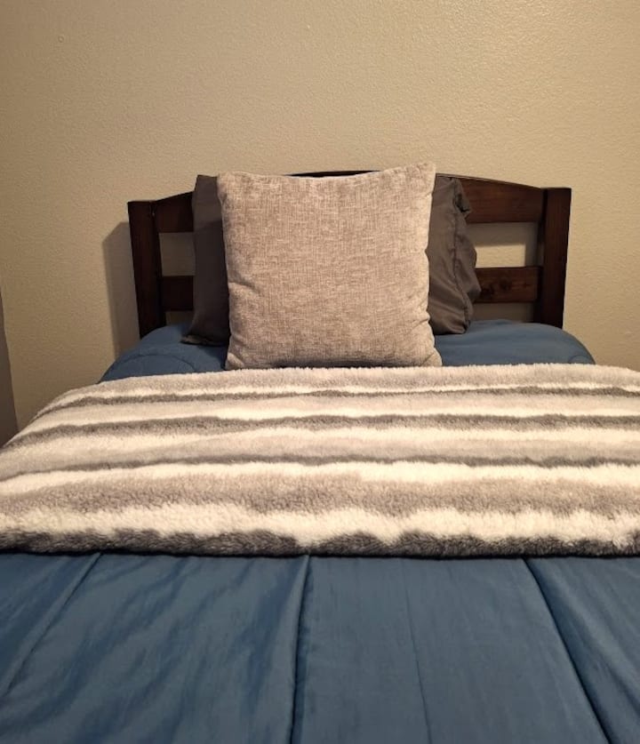 O quarto 3 tem duas camas de solteiro, cobertores extras, uma mesa de cabeceira, um candeeiro e um armário com um porta-malas para guardar pertences.