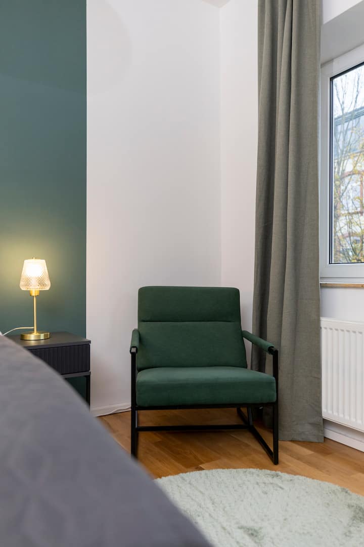 Katika chumba kikuu cha kulala, kiti cha kustarehesha kinakualika uketi na kufurahia wakati huu. Iwe na kitabu kizuri au kuondoa plagi tu – eneo hili ni lako tu. 