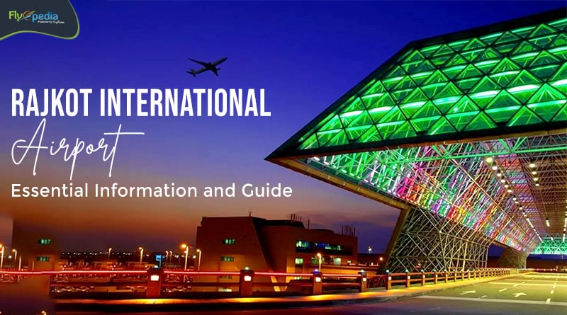 The exterior of Rajkot International Airport is illuminated with vibrant colored lights, creating an eye-catching display. The modern architecture features a triangular glass roof, reflecting the bright hues. An airplane is visible in the sky above, adding to the dynamic atmosphere of the busy airport.