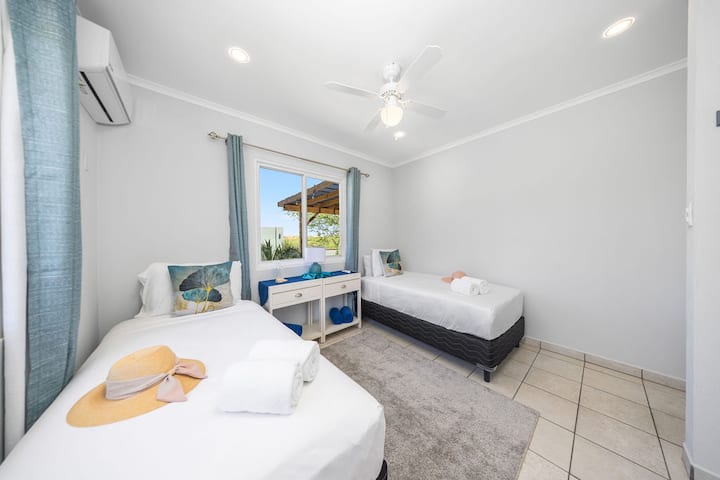 Táto izba je ideálna pre hostí alebo rodinu a ponúka dve samostatné postele, televízor na zábavu, štýlové zrkadlo, svetlé okná na prirodzené svetlo a dostatok úložného priestoru v skrinke. Pohodlie a pohodlie v jednom príjemnom priestore!