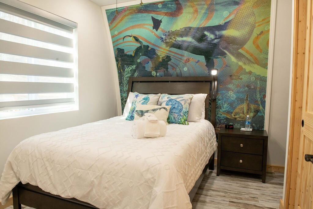 Deze gezellige slaapkamer met marinesthema is voorzien van een groot bed, wat een ontspannend toevluchtsoord creëert. Met zorg ontworpen voor comfort en gemak, omvat het nachtkastje, een nachtkastje, een dressoir, een  kast en een kofferstandaard, met voldoende opbergruimte.