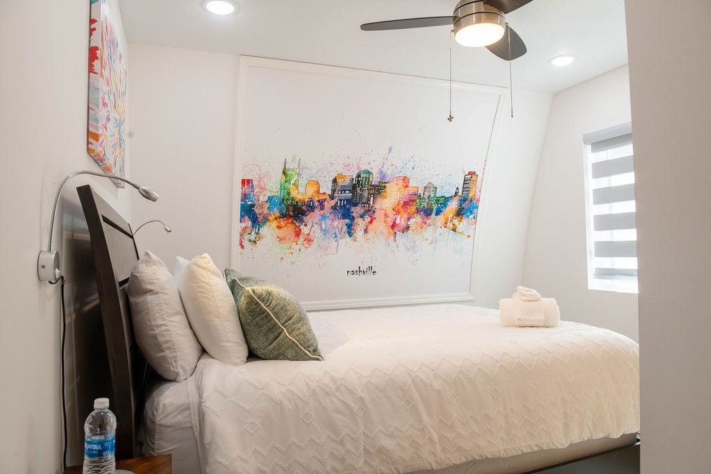 Slaapkamer 3 beschikt over een queensize bed, een eigen badkamer en een muurschildering in Nashville voor een echte vakantie-ervaring. Geniet van verlichting aan het bed, voldoende opbergruimte, verduisterende gordijnen en een tv voor ultiem comfort. 
