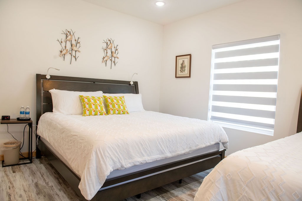 Deze slaapkamer op de benedenverdieping heeft een kingsize bed en een tweepersoonsbed met een charmant vogelthema. Het beschikt over een grote kast, dressoir, nachtkastjes met stopcontacten om op te laden en bedverlichting voor extra gemak.