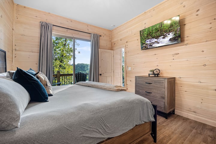 2 des 2 chambres situées au niveau inférieur, lit king size, télévision connectée 50 pouces. Portes coulissantes donnant sur la terrasse, avec des sièges juste à l'extérieur de la porte.